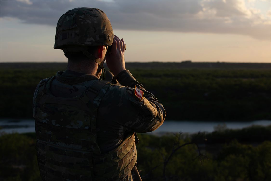Soldier conducting surveillance operations with military binoculars