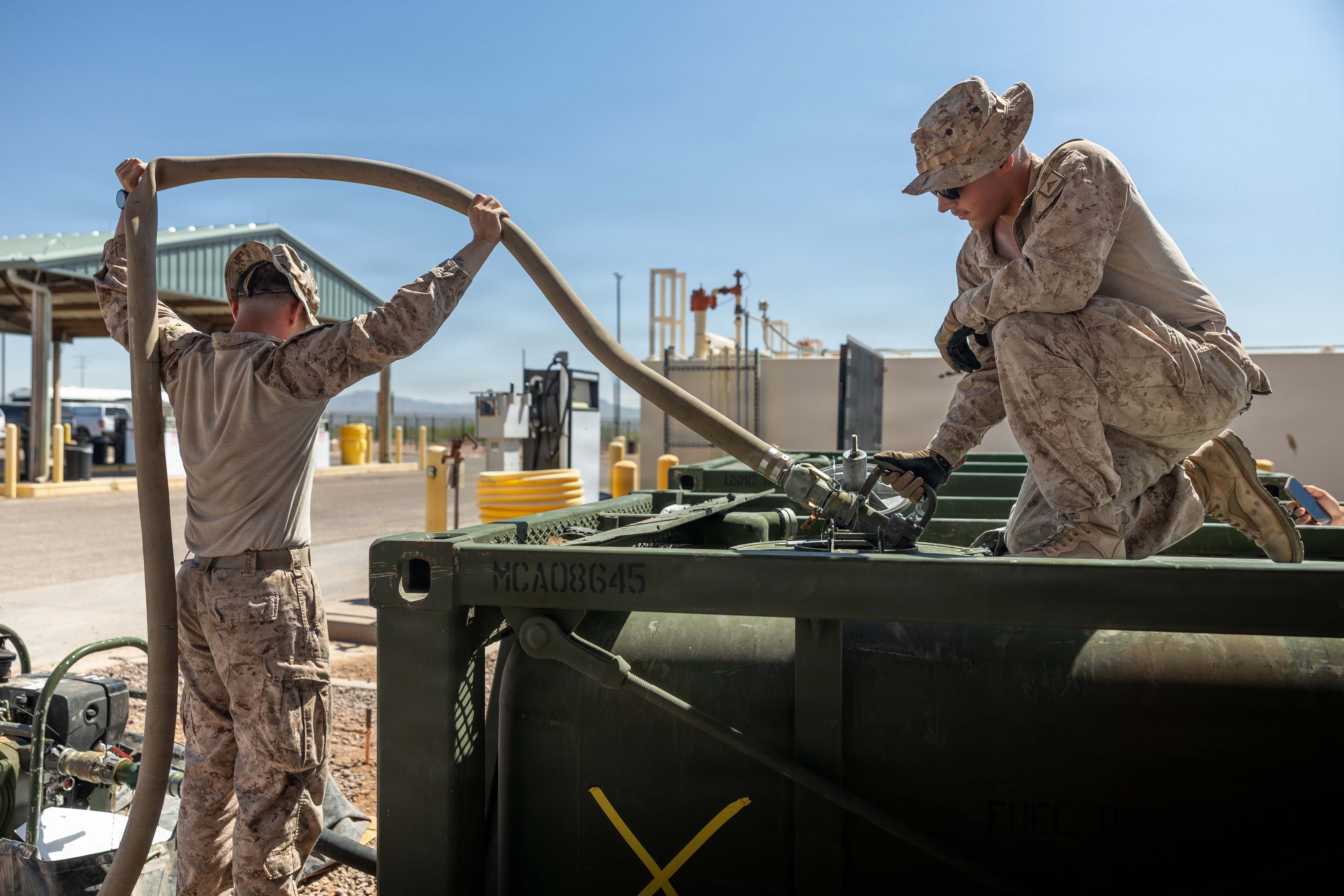 Marines connecting fuel hoses for petroleum supply operations
